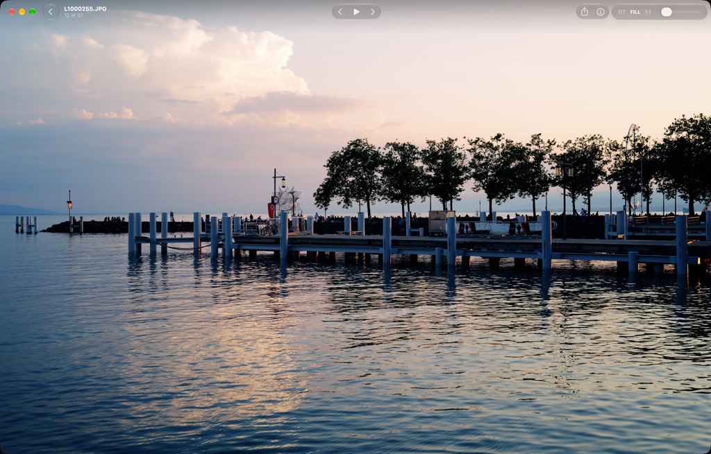 A photograph of a pier at dusk fills the window. The window bar shows the filename, previous and next, and the zoom controls.